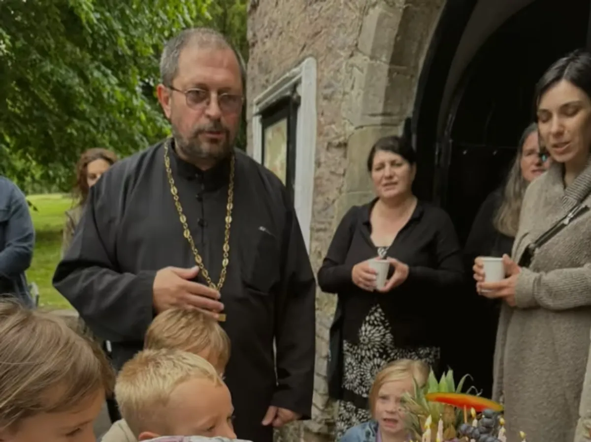 Priest greeting parishioners outside St. Andrew's